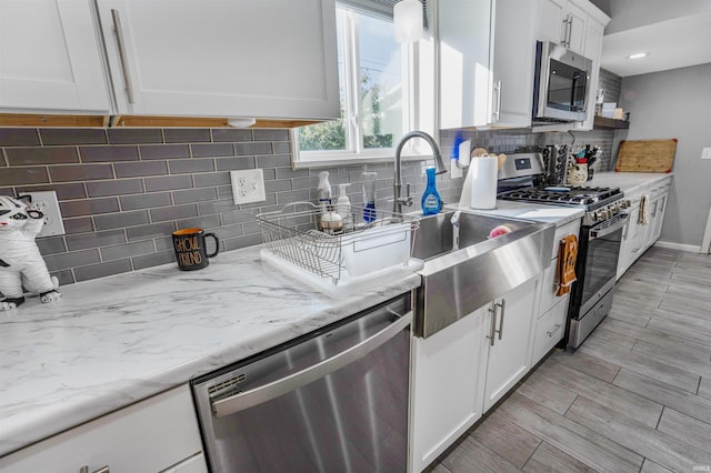 104 N Jefferson St, Pine Village, IN 47975 - kitchen with appliances with stainless steel finishes, decorative backsplash, white cabinets, light stone counters, and baseboards
