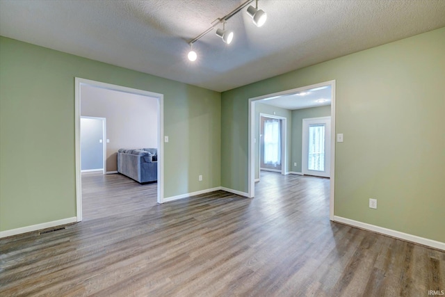 1063 S Colchester Ct, Bloomington, IN 47401 - spare room featuring wood finished floors, baseboards, and a textured ceiling