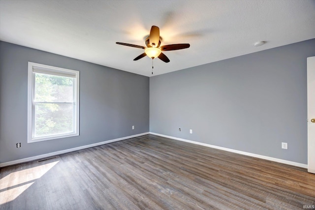 1063 S Colchester Ct, Bloomington, IN 47401 - unfurnished room with ceiling fan, baseboards, dark wood-style flooring, and a smoke detector