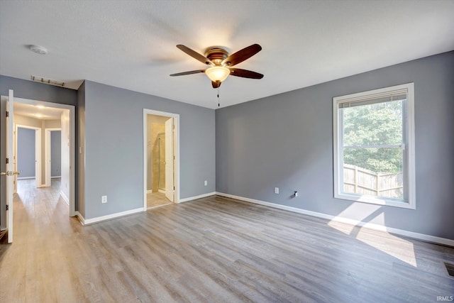 1063 S Colchester Ct, Bloomington, IN 47401 - unfurnished bedroom featuring baseboards, wood finished floors, ensuite bathroom, and ceiling fan