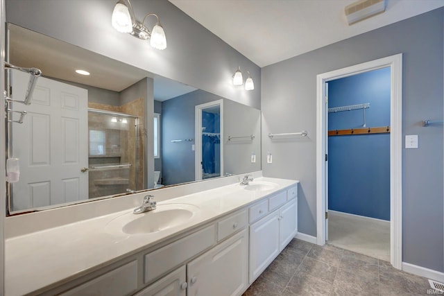 1063 S Colchester Ct, Bloomington, IN 47401 - full bathroom featuring toilet, a stall shower, double vanity, baseboards, and a walk in closet
