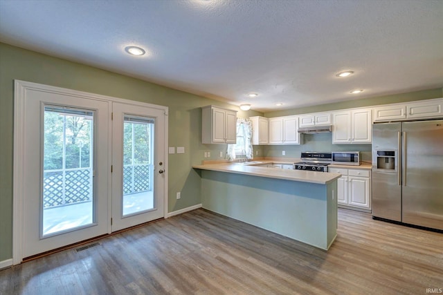 1063 S Colchester Ct, Bloomington, IN 47401 - kitchen featuring appliances with stainless steel finishes, light wood finished floors, light countertops, a peninsula, and recessed lighting