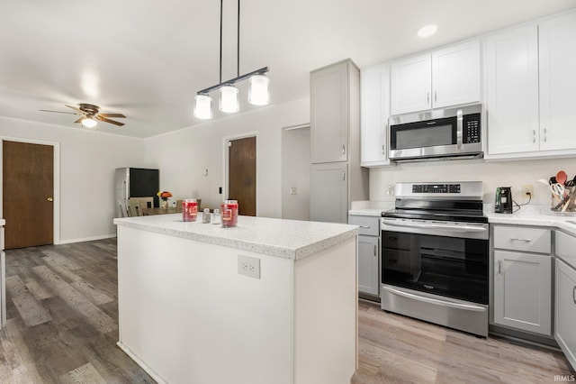1210 Mcintyre Dr, Auburn, IN 46706 - kitchen featuring stainless steel appliances, ceiling fan, a center island, light countertops, and light wood finished floors