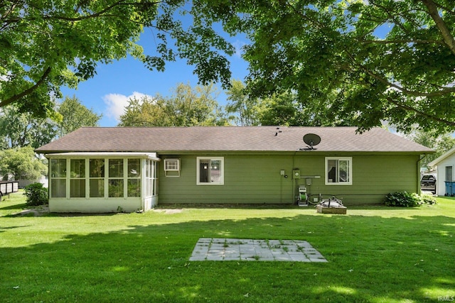 1210 Mcintyre Dr, Auburn, IN 46706 - rear view of property featuring a sunroom, a lawn, roof with shingles, and a patio area