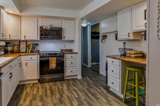 407 S Colony Dr, Garrett, IN 46738 - kitchen featuring stainless steel appliances, white cabinetry, dark wood-style flooring, and dark stone countertops