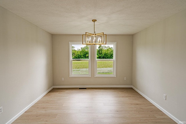 2135 Old Oak Dr, West Lafayette, IN 47906 - empty room featuring a chandelier, light wood-style floors, baseboards, and a textured ceiling