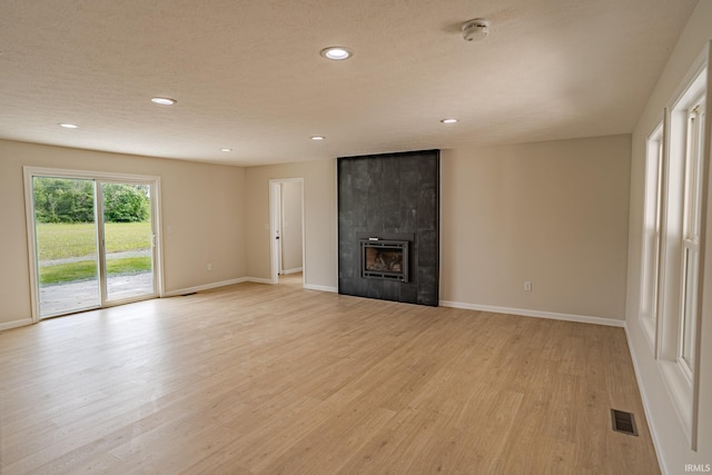 2135 Old Oak Dr, West Lafayette, IN 47906 - unfurnished living room featuring light wood-type flooring, recessed lighting, baseboards, and a tiled fireplace