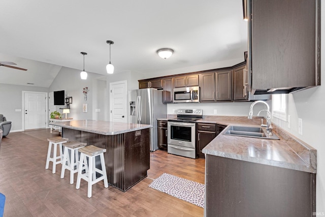 15926 Continental Dr, Huntertown, IN 46748 - kitchen featuring stainless steel appliances, a sink, light wood finished floors, a breakfast bar area, and open floor plan