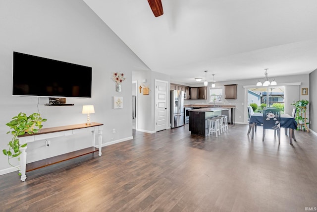 15926 Continental Dr, Huntertown, IN 46748 - living room featuring baseboards, dark wood-style floors, vaulted ceiling, a chandelier, and a ceiling fan