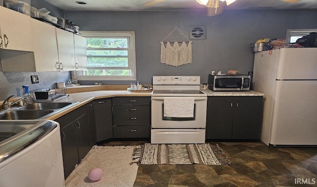 1104 Alder Dr, Lafayette, IN 47909 - kitchen featuring white appliances, a sink, dark stone finish floors, and light countertops