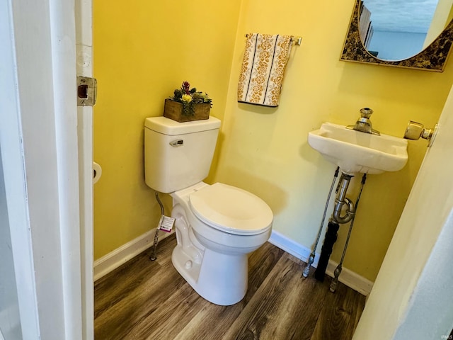 42 Center St, Avoca, IN 47420 - half bath with toilet, wood finished floors, baseboards, and a sink