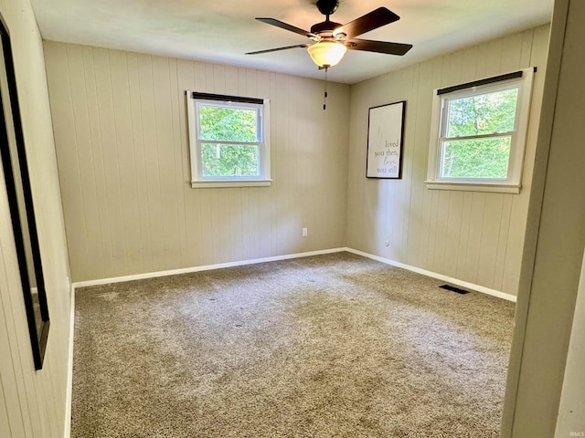 42 Center St, Avoca, IN 47420 - carpeted spare room featuring a ceiling fan, wood walls, and baseboards