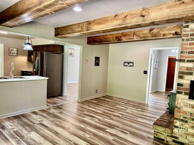 42 Center St, Avoca, IN 47420 - unfurnished living room with a sink, light wood-style flooring, beam ceiling, and baseboards