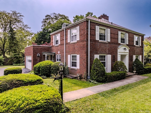 308 N Forest Ave, Muncie, IN 47304 - view of front of home featuring brick siding, a chimney, a front lawn, an attached garage, and a standing seam roof