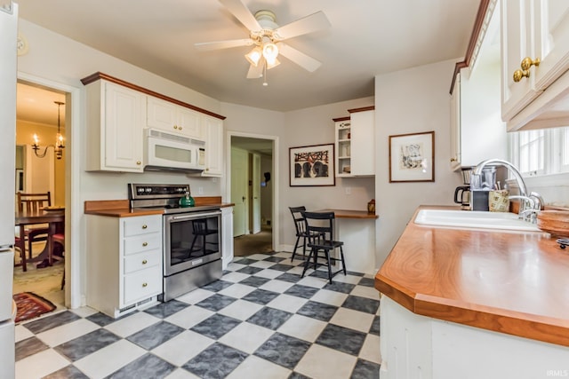 308 N Forest Ave, Muncie, IN 47304 - kitchen featuring white microwave, stainless steel electric range oven, a sink, tile patterned floors, and wooden counters
