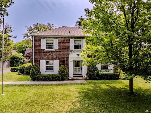 308 N Forest Ave, Muncie, IN 47304 - view of front facade featuring a front yard, brick siding, french doors, and a chimney