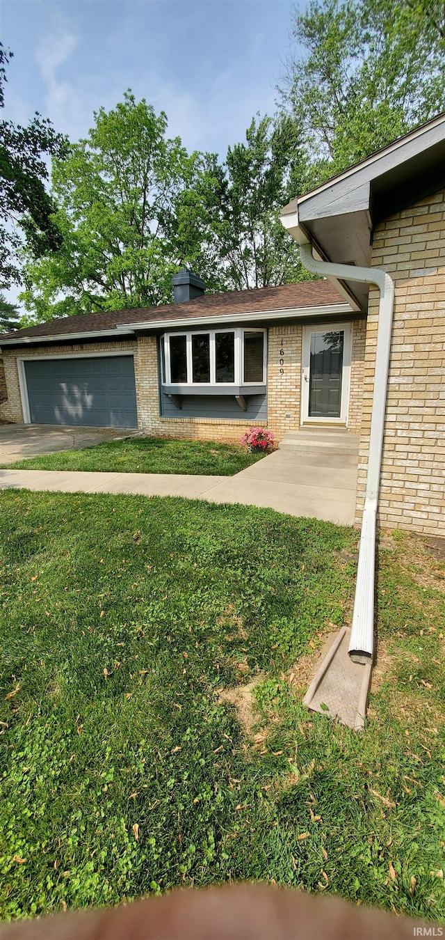 1609 Gordon Dr, Kokomo, IN 46902 - view of front facade featuring brick siding, a front yard, and a garage