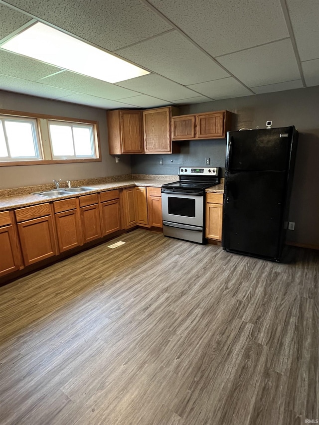 443 S State St, Sullivan, IN 47882 - kitchen featuring stainless steel range with electric cooktop, freestanding refrigerator, a sink, a drop ceiling, and brown cabinets