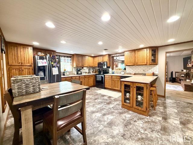 981 Keyser Ln, Richmond, IN 47374 - kitchen with appliances with stainless steel finishes, brown cabinetry, recessed lighting, light countertops, and decorative backsplash