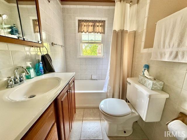 981 Keyser Ln, Richmond, IN 47374 - full bath with tile walls, toilet, vanity, shower / bathtub combination with curtain, and decorative backsplash