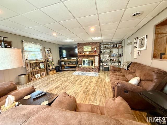 981 Keyser Ln, Richmond, IN 47374 - living area featuring wood finished floors, a brick fireplace, and a paneled ceiling
