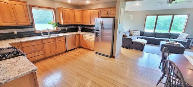 360 E 350 Rd N, Warsaw, IN 46582 - kitchen featuring appliances with stainless steel finishes, open floor plan, a sink, a ceiling fan, and light wood-style flooring