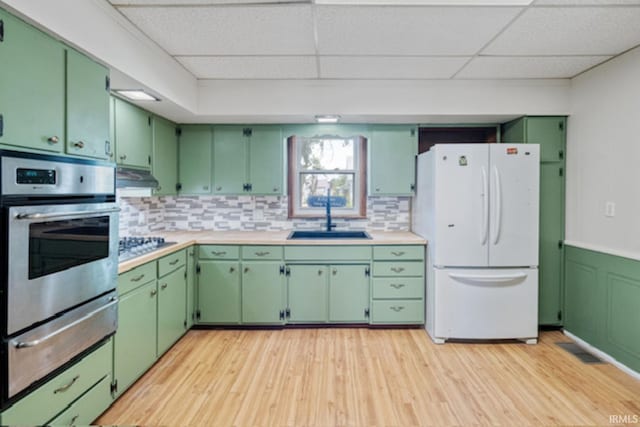 128 E Grant St, Greentown, IN 46936 - kitchen with appliances with stainless steel finishes, a sink, a warming drawer, a drop ceiling, and light countertops