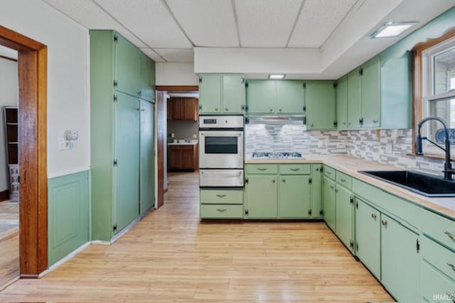 128 E Grant St, Greentown, IN 46936 - kitchen featuring oven, a warming drawer, a sink, and light wood-type flooring
