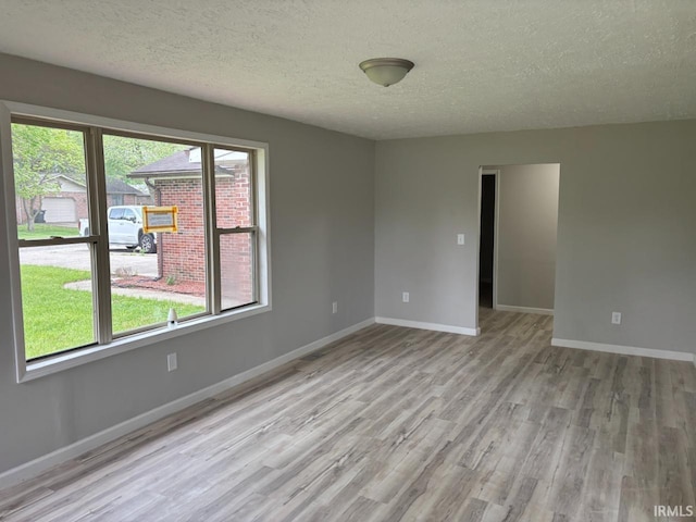 724 Iroquois Dr, Anderson, IN 46012 - unfurnished room featuring light wood-style floors, a textured ceiling, and baseboards