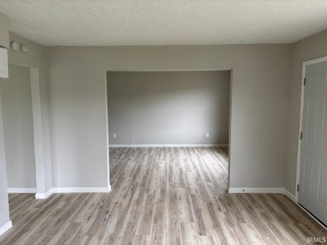 724 Iroquois Dr, Anderson, IN 46012 - empty room featuring light wood finished floors, a textured ceiling, and baseboards
