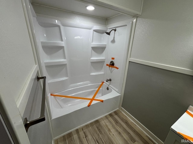 724 Iroquois Dr, Anderson, IN 46012 - bathroom with wood finished floors, shower / washtub combination, baseboards, and a textured wall