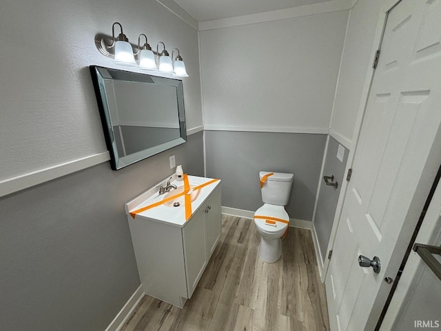 724 Iroquois Dr, Anderson, IN 46012 - half bath with wood finished floors, toilet, vanity, and baseboards
