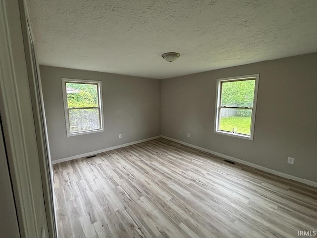 724 Iroquois Dr, Anderson, IN 46012 - unfurnished room featuring plenty of natural light, light wood-style flooring, baseboards, and a textured ceiling
