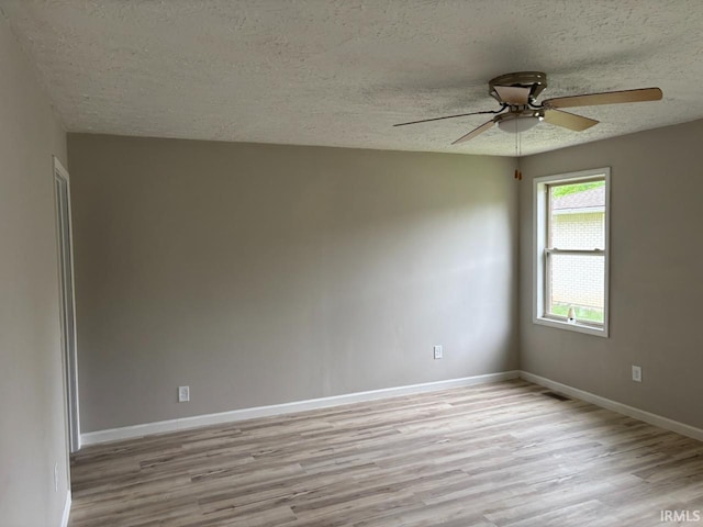 724 Iroquois Dr, Anderson, IN 46012 - spare room with a textured ceiling, light wood finished floors, a ceiling fan, and baseboards