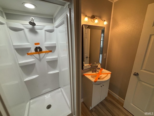 724 Iroquois Dr, Anderson, IN 46012 - bathroom with wood finished floors, a stall shower, vanity, and baseboards
