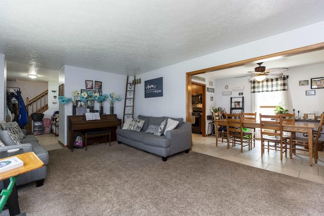 1617 Bennington Dr, Mishawaka, IN 46544 - living room featuring light carpet, a textured ceiling, a ceiling fan, light tile patterned floors, and stairway