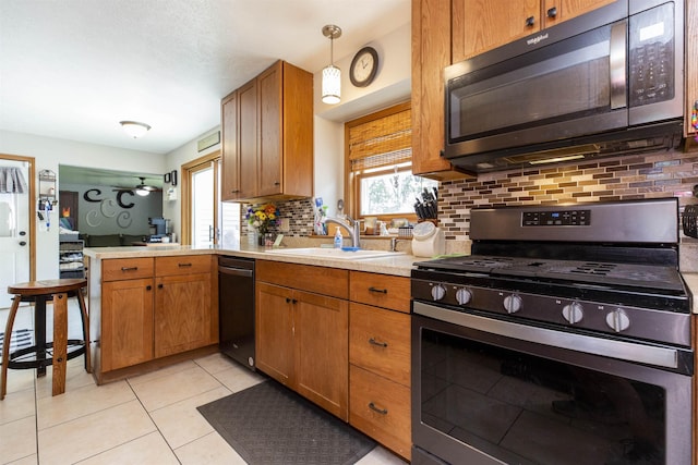 1617 Bennington Dr, Mishawaka, IN 46544 - kitchen featuring black microwave, gas range, a sink, backsplash, and light countertops