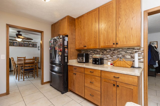 1617 Bennington Dr, Mishawaka, IN 46544 - kitchen featuring black refrigerator with ice dispenser, backsplash, light tile patterned floors, light countertops, and ceiling fan