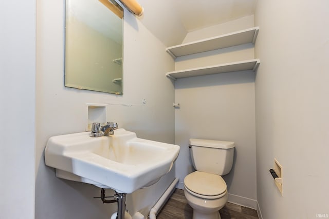 7782 S Warren Rd, Warren, IN 46792 - half bath with wood finished floors, toilet, a sink, and baseboards