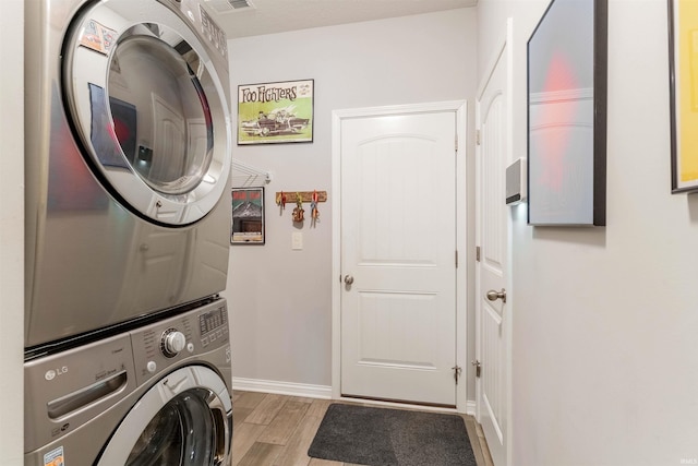 7937 Boydon Ct, Evansville, IN 47715 - laundry room with stacked washer / dryer, light wood-style floors, and baseboards