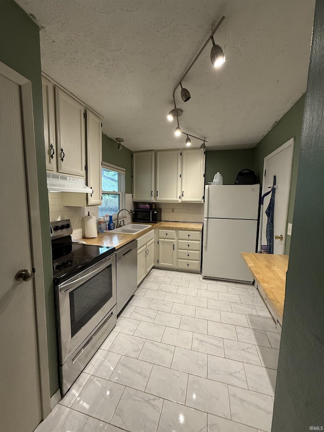3224 Commanche Trl, Lafayette, IN 47909 - kitchen with appliances with stainless steel finishes, a sink, light countertops, tasteful backsplash, and under cabinet range hood