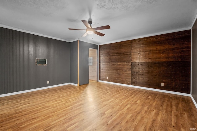 211 Condo St, Monticello, IN 47960 - unfurnished room with a ceiling fan, light wood finished floors, baseboards, crown molding, and wood walls