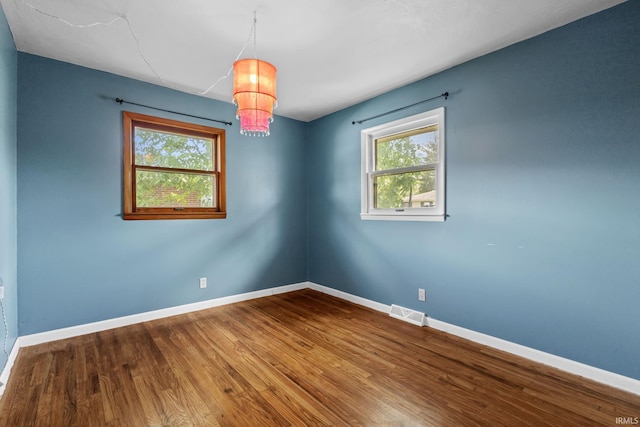 211 Condo St, Monticello, IN 47960 - unfurnished room featuring wood finished floors, baseboards, and a chandelier