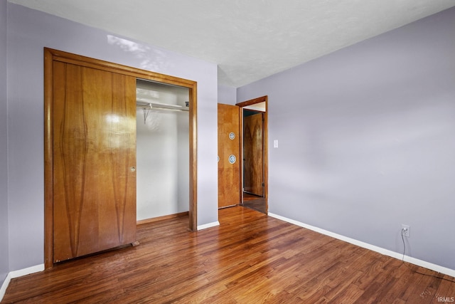 211 Condo St, Monticello, IN 47960 - unfurnished bedroom featuring wood finished floors, baseboards, and a closet