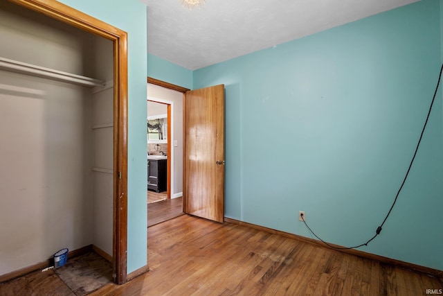 211 Condo St, Monticello, IN 47960 - unfurnished bedroom with light wood finished floors, baseboards, and a sink