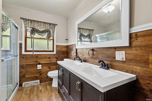 211 Condo St, Monticello, IN 47960 - full bath with wooden walls, double vanity, toilet, a stall shower, and wood finished floors