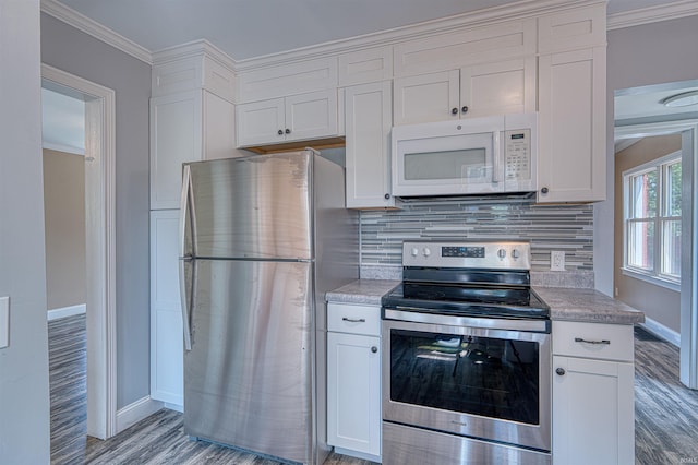3017 E Walnut St, Evansville, IN 47714 - kitchen with stainless steel appliances, baseboards, decorative backsplash, white cabinets, and ornamental molding