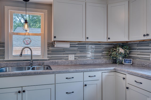 3017 E Walnut St, Evansville, IN 47714 - kitchen with a sink, white cabinetry, backsplash, and hanging light fixtures