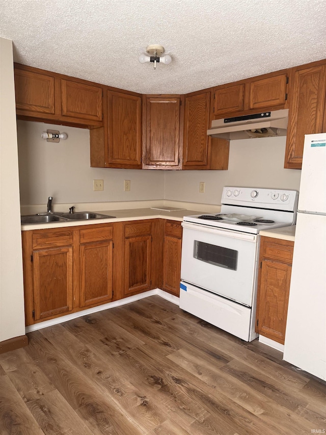 1406 N Philips St, Kokomo, IN 46901 - kitchen with white appliances, under cabinet range hood, brown cabinets, and a textured ceiling
