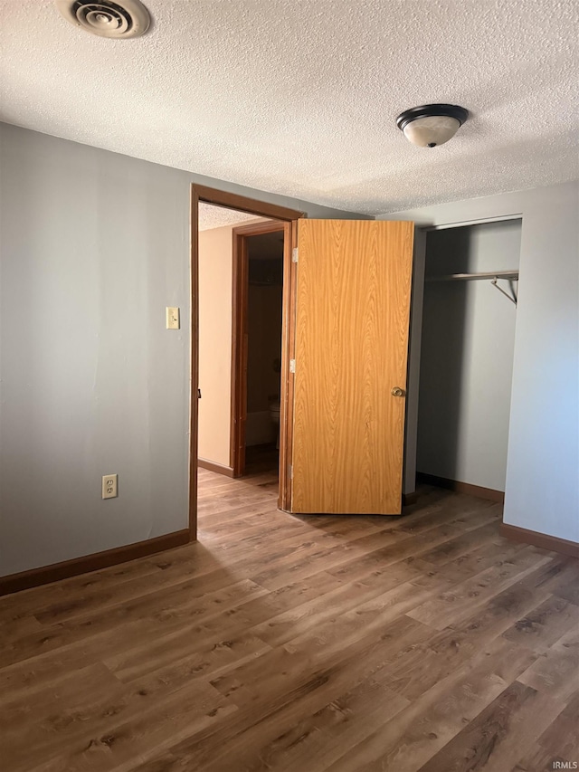 1406 N Philips St, Kokomo, IN 46901 - unfurnished bedroom with a textured ceiling, wood finished floors, a closet, and baseboards